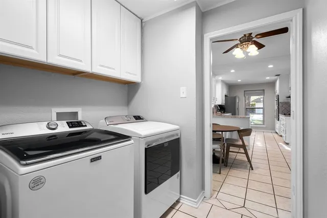 a kitchen that has a sink and a stove with white cabinets
