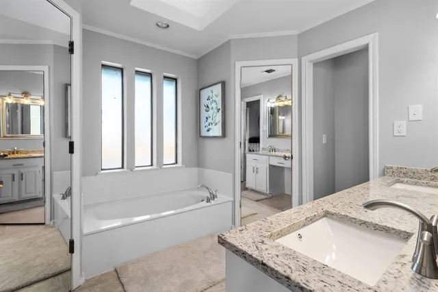 a bathroom with a granite countertop tub sink and mirror