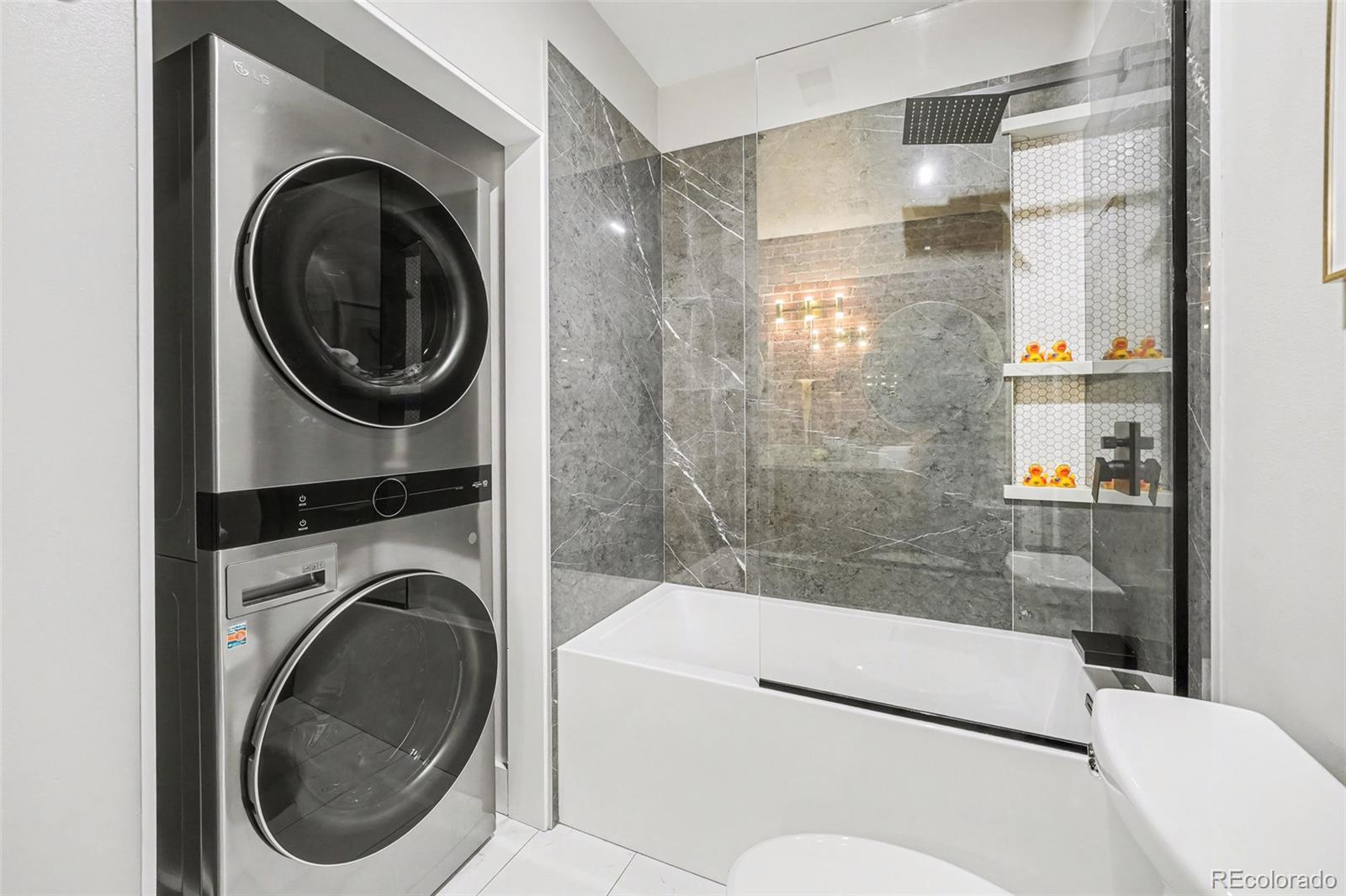 2960 Inca Street, Unit 103 Denver, CO 80202 - Photo 11 of 28 a bathroom with a sink a washer and dryer