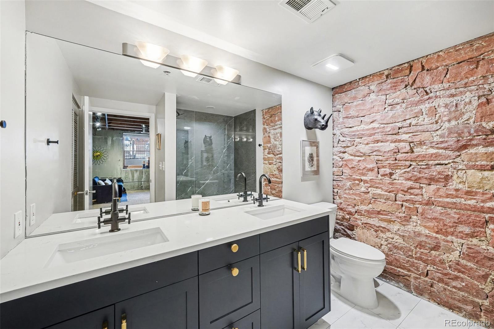 2960 Inca Street, Unit 103 Denver, CO 80202 - Photo 17 of 28 a bathroom with a double vanity sink toilet and a mirror