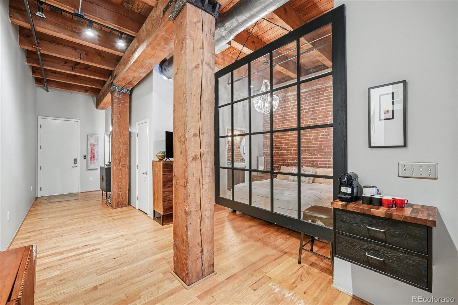 2960 Inca Street, Unit 103 Denver, CO 80202 - Photo 7 of 28 a bedroom with a bed and wooden floor