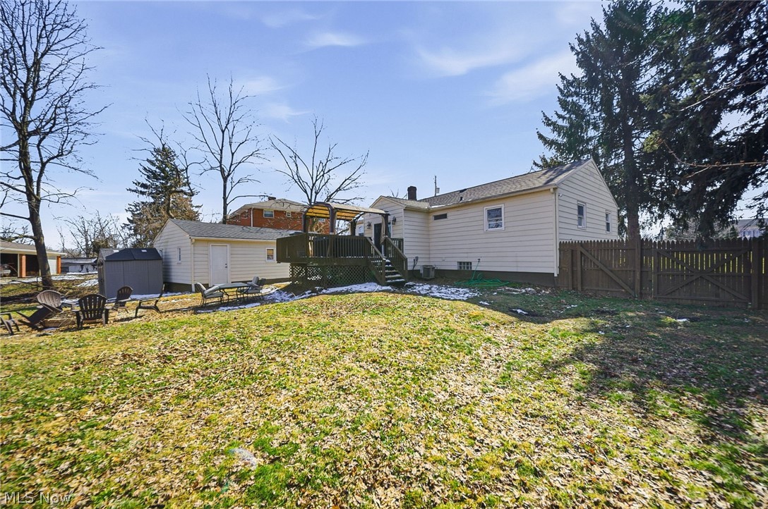3905 Kent Road Stow, OH 44224 - Photo 42 of 45 Back of property featuring a fire pit, a gate, a wooden deck, a storage shed, and a fenced backyard