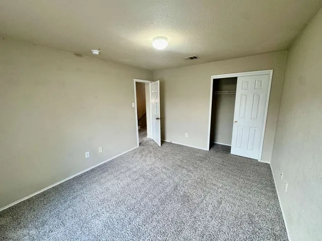 an empty room with closet and a bathroom