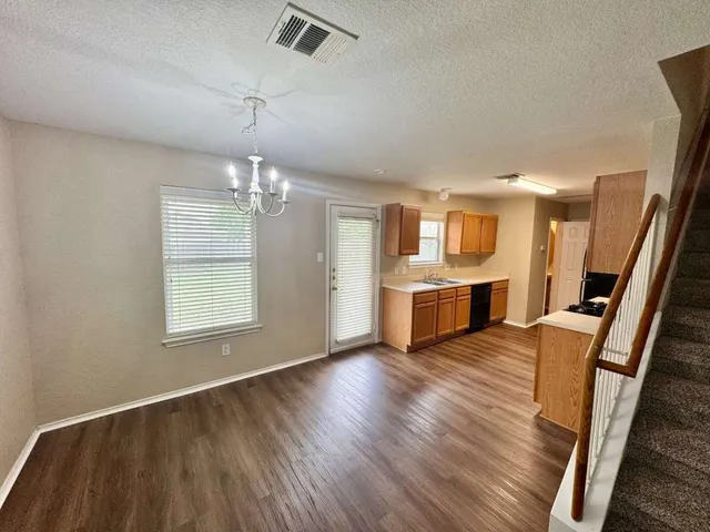 a view of a big room with wooden floor and windows