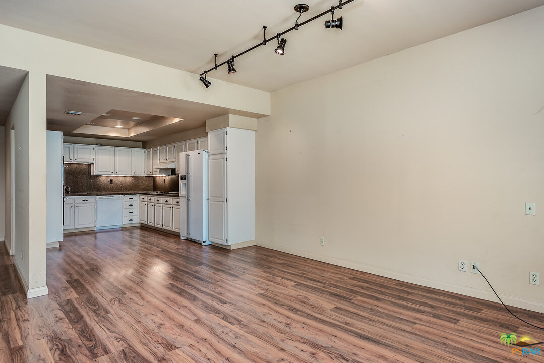 910 Island Drive, Unit 107 Rancho Mirage, CA 92270 - Photo 11 of 23 a view of a kitchen with wooden floor and a refrigerator
