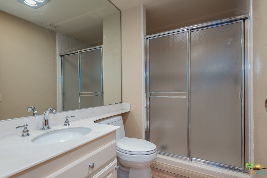 910 Island Drive, Unit 107 Rancho Mirage, CA 92270 - Photo 15 of 23 a bathroom with a granite countertop sink toilet and shower