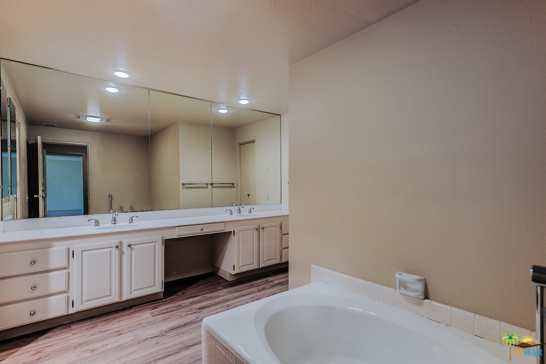 910 Island Drive, Unit 107 Rancho Mirage, CA 92270 - Photo 20 of 23 a spacious bathroom with a double vanity sink and a mirror
