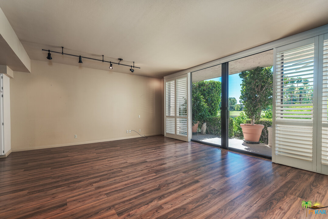 910 Island Drive, Unit 107 Rancho Mirage, CA 92270 - Photo 4 of 23 a view of an empty room with wooden floor and a window