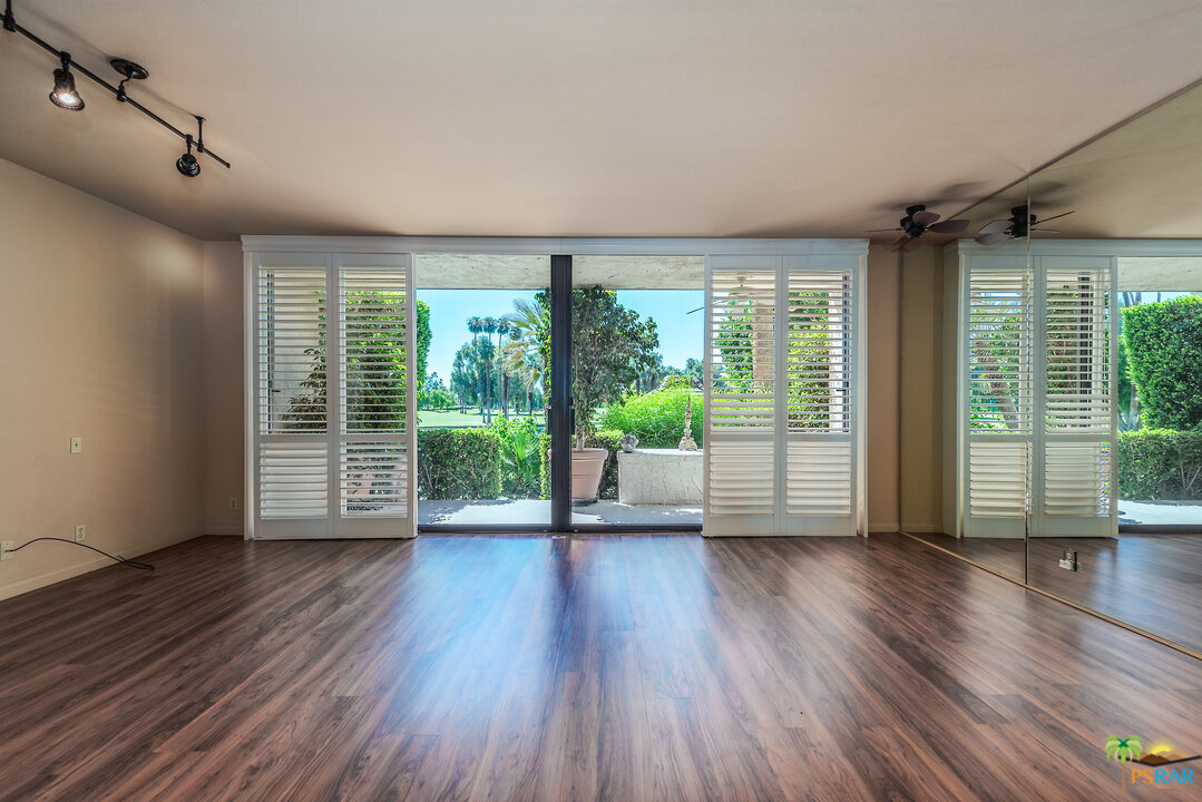 910 Island Drive, Unit 107 Rancho Mirage, CA 92270 - Photo 5 of 23 a view of an empty room with wooden floor and a window