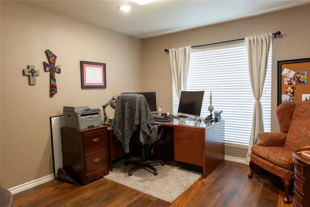 a view of a workspace with furniture and a window