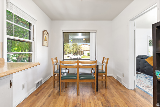 372 800 East Provo, UT 84606 - Photo 9 of 29 Dining area featuring wood-finish flooring, white walls, and prominent windows