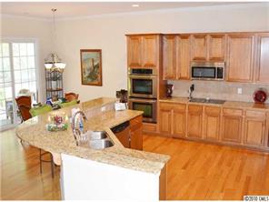 580 Quicksilver Trail Fort Mill, SC 29708 - Photo 6 of 16 a kitchen with stainless steel appliances granite countertop a sink a stove and a wooden cabinets