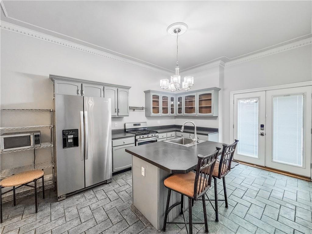 52 South 18th Street Pittsburgh, PA 15203 - Photo 2 of 26 a kitchen with stainless steel appliances granite countertop a refrigerator a stove a kitchen island a dining table and chairs