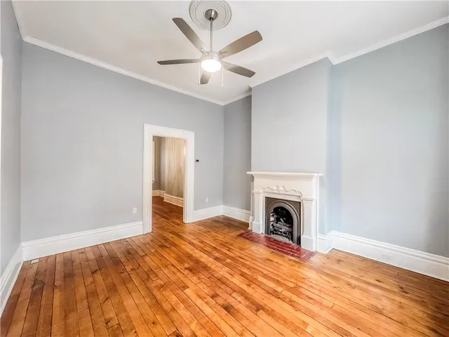 a view of empty room with fireplace and wooden floor