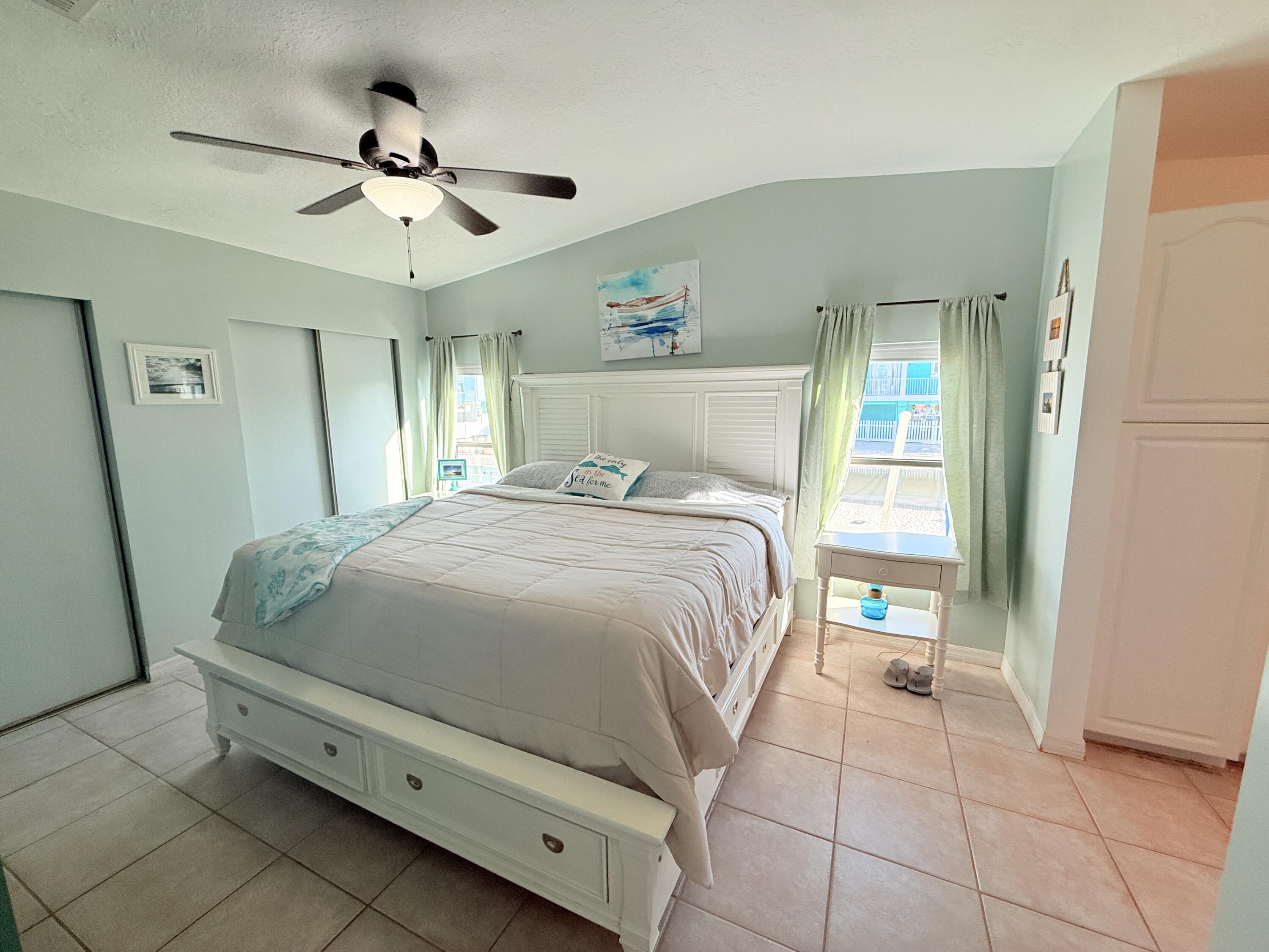 723 Boyd Drive Key Largo, FL 33037 - Photo 23 of 56 a bedroom with a bed and a chandelier