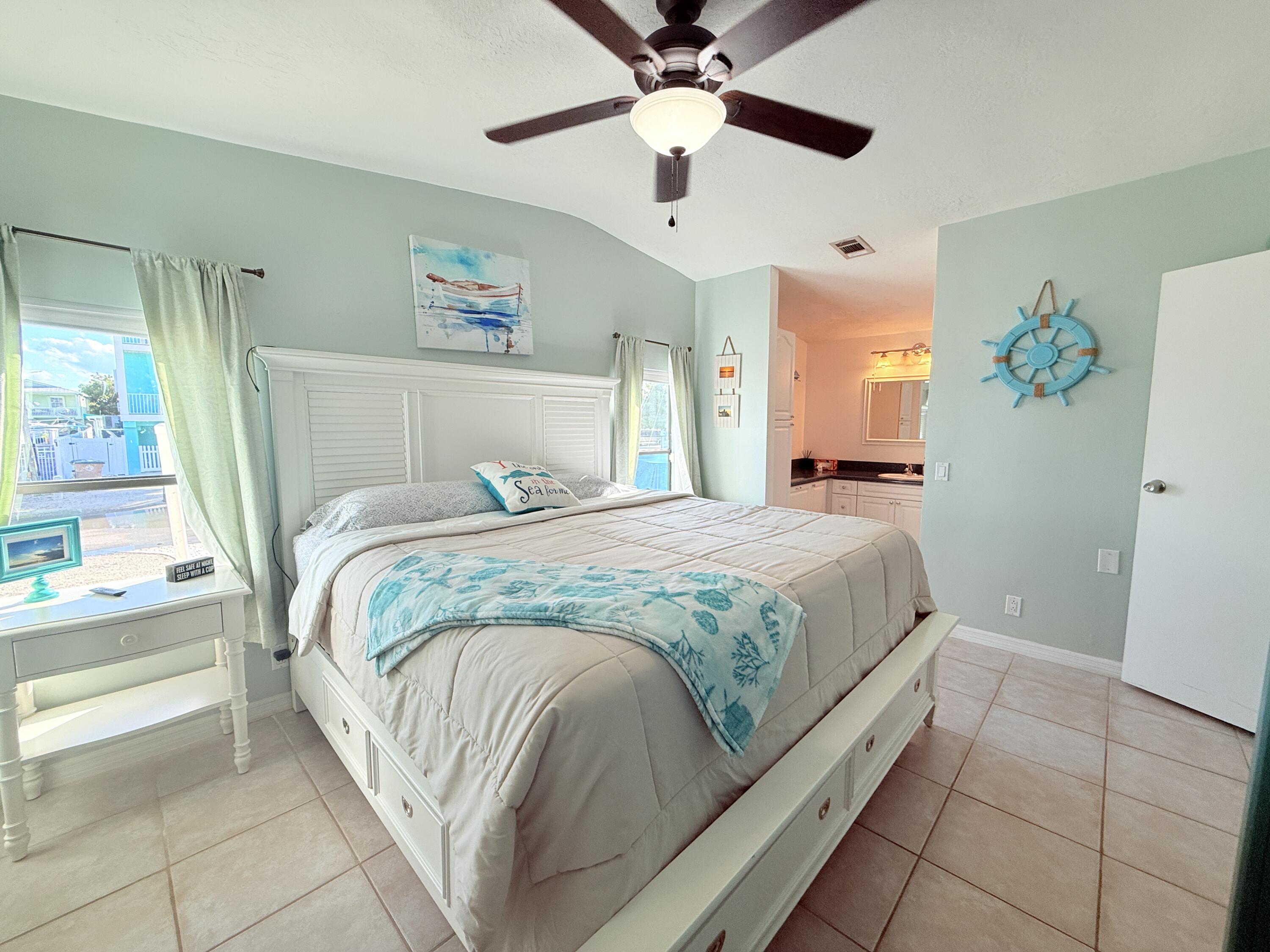 723 Boyd Drive Key Largo, FL 33037 - Photo 24 of 56 a bedroom with a bed and a chandelier