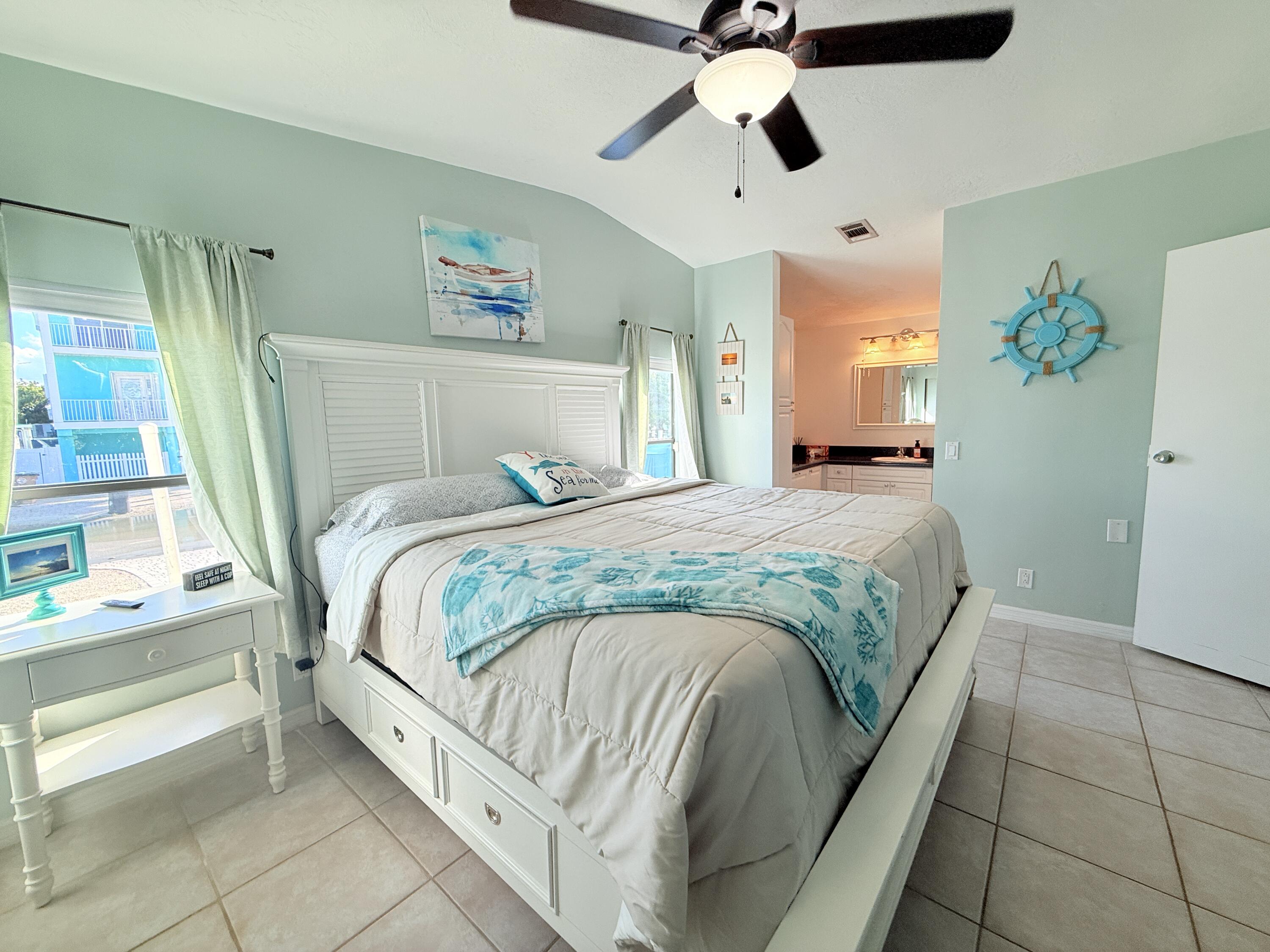 723 Boyd Drive Key Largo, FL 33037 - Photo 25 of 56 a bedroom with a bed and a chandelier