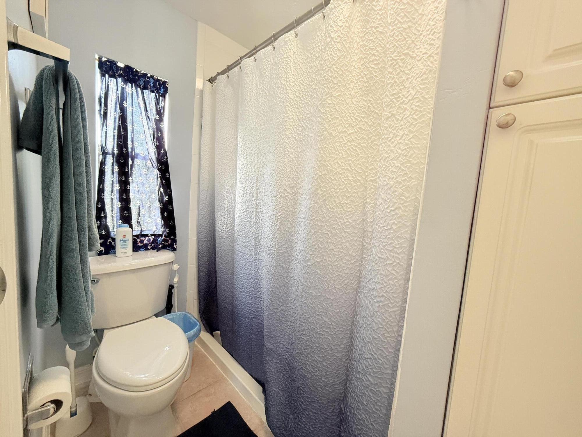 723 Boyd Drive Key Largo, FL 33037 - Photo 29 of 56 a white toilet sitting next to a shower curtain