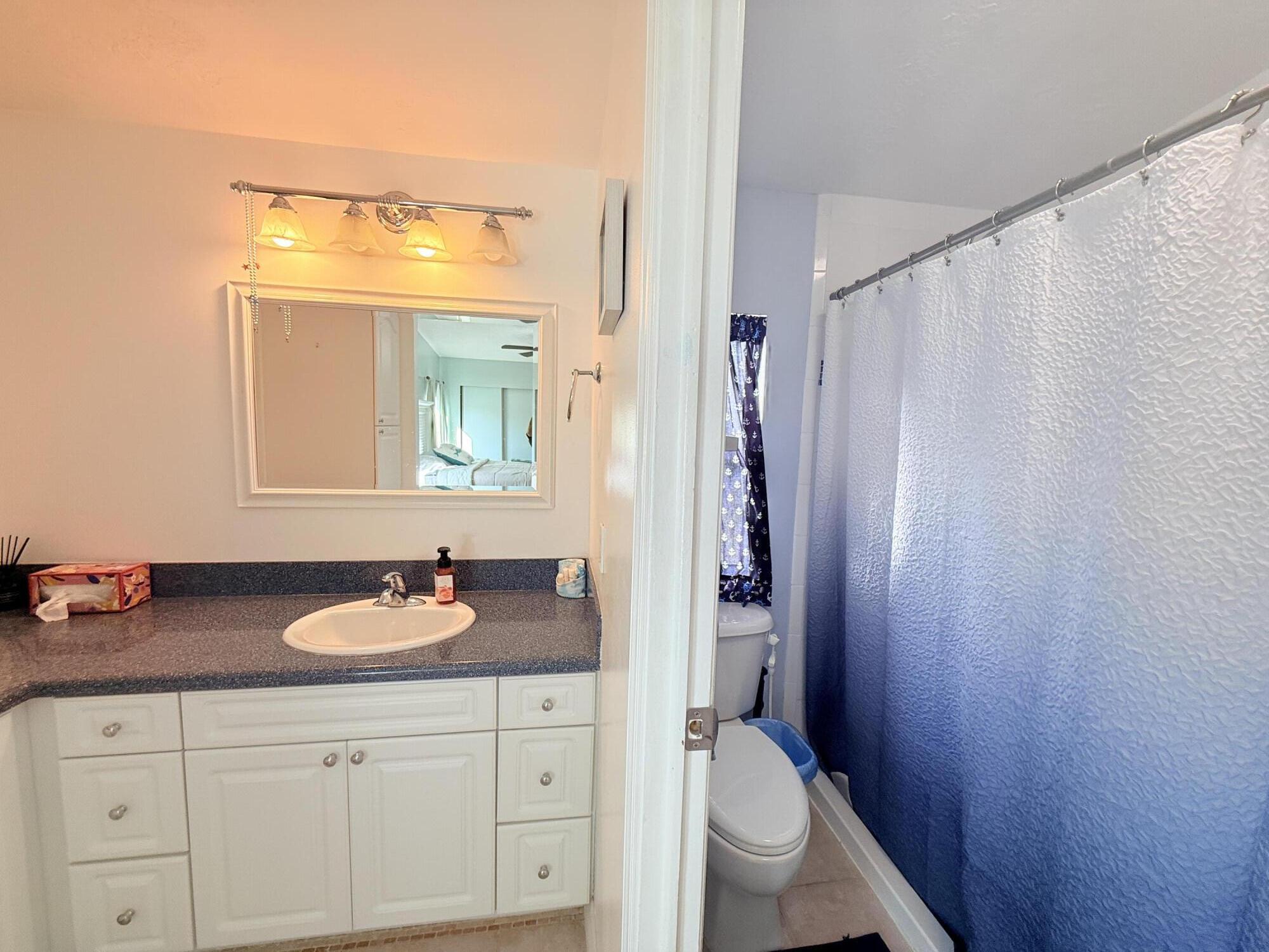 723 Boyd Drive Key Largo, FL 33037 - Photo 30 of 56 a bathroom with a granite countertop sink vanity mirror and toilet