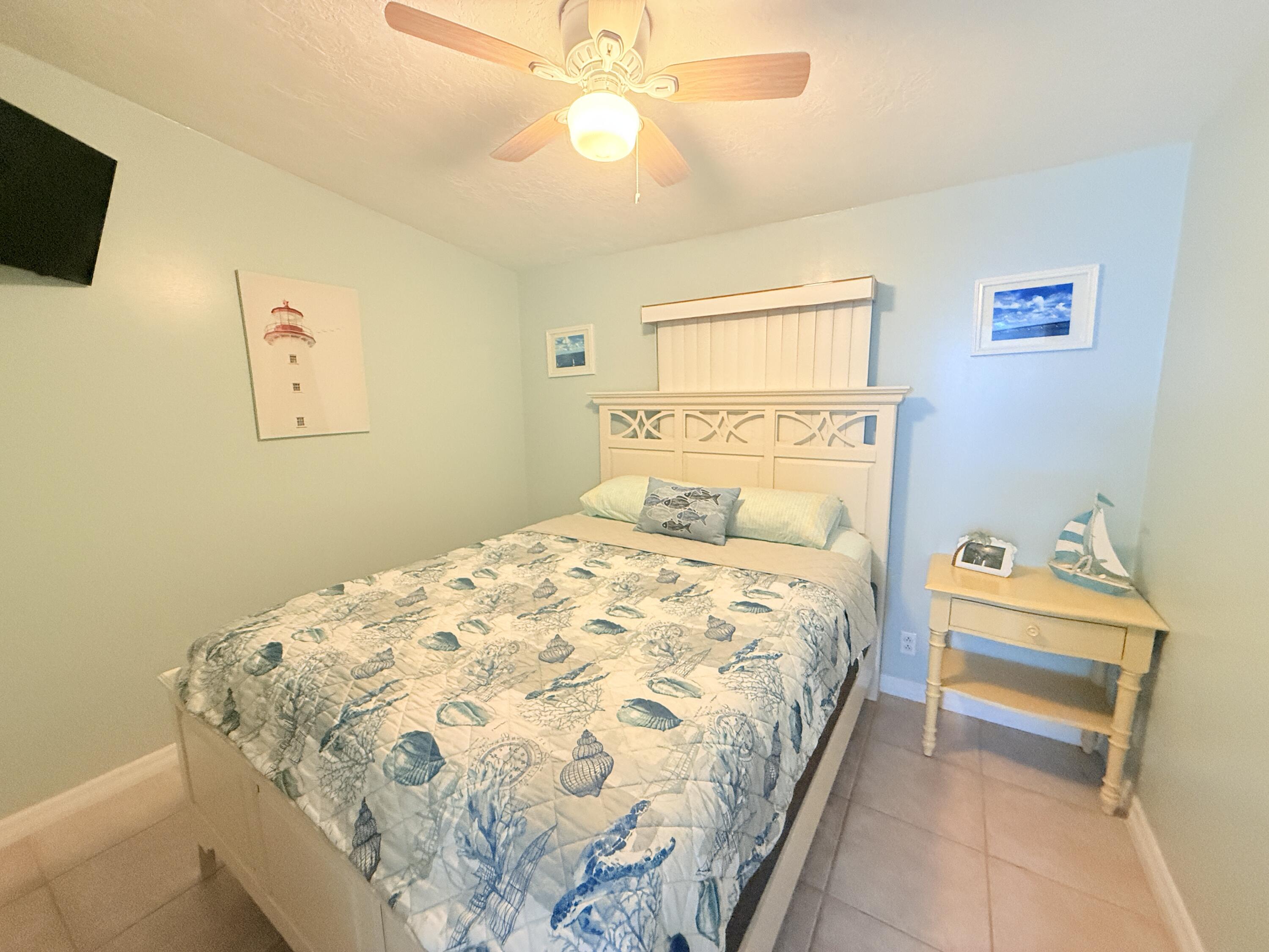 723 Boyd Drive Key Largo, FL 33037 - Photo 31 of 56 a bedroom with a bed and a chandelier