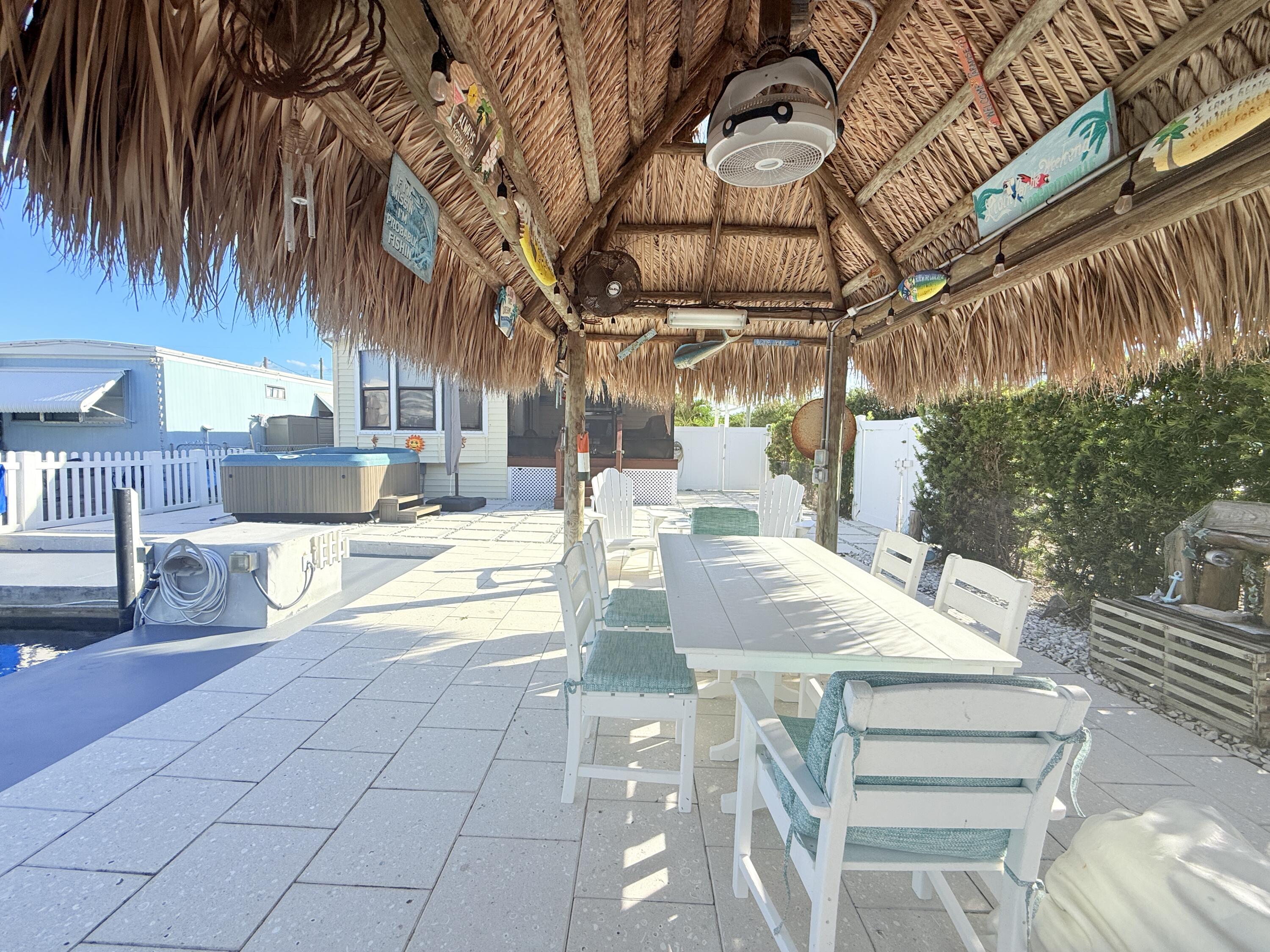 723 Boyd Drive Key Largo, FL 33037 - Photo 46 of 56 a view of a patio with table and chairs with wooden floor and fence