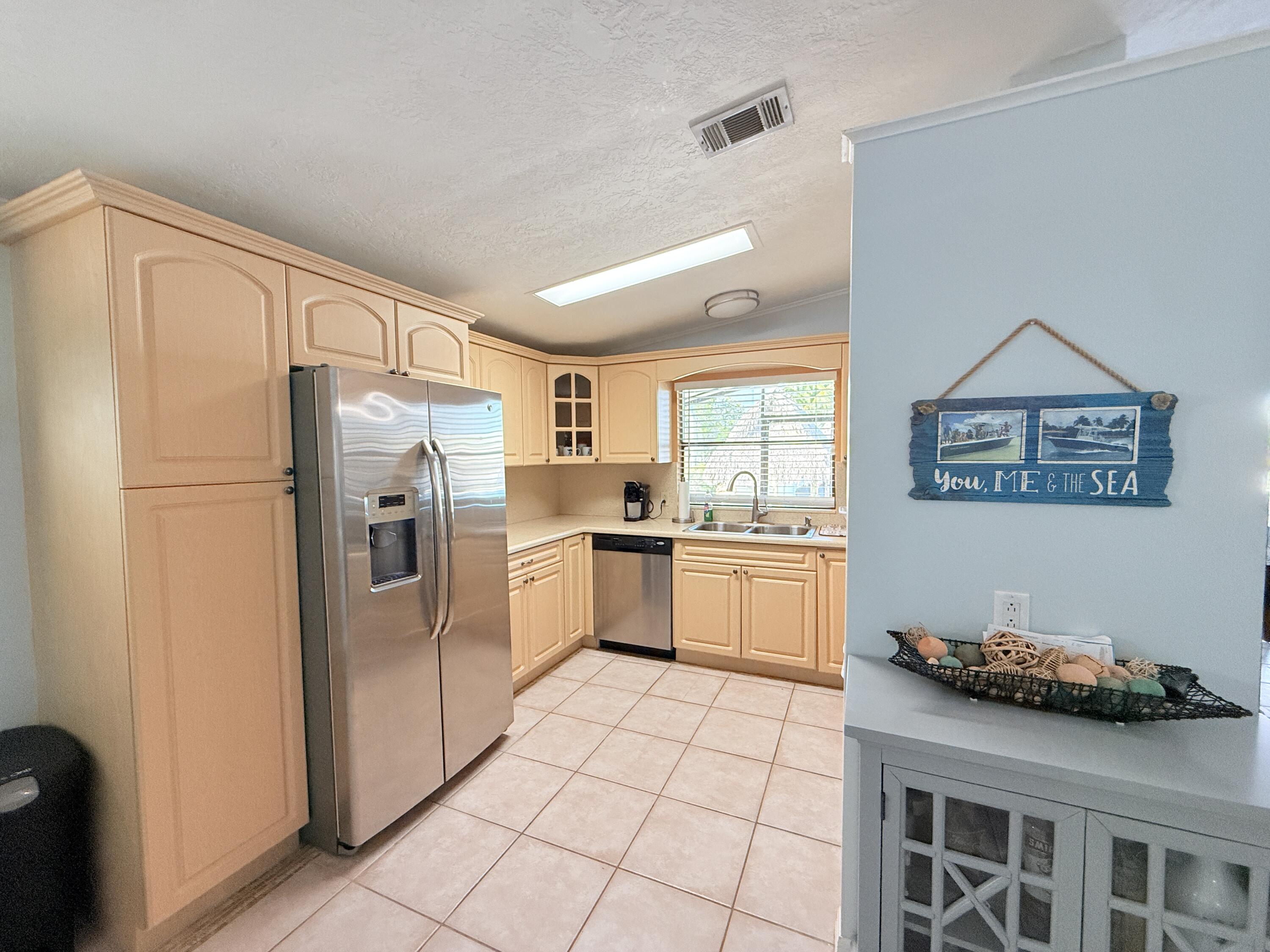 723 Boyd Drive Key Largo, FL 33037 - Photo 9 of 56 a kitchen with stainless steel appliances a refrigerator sink and cabinets