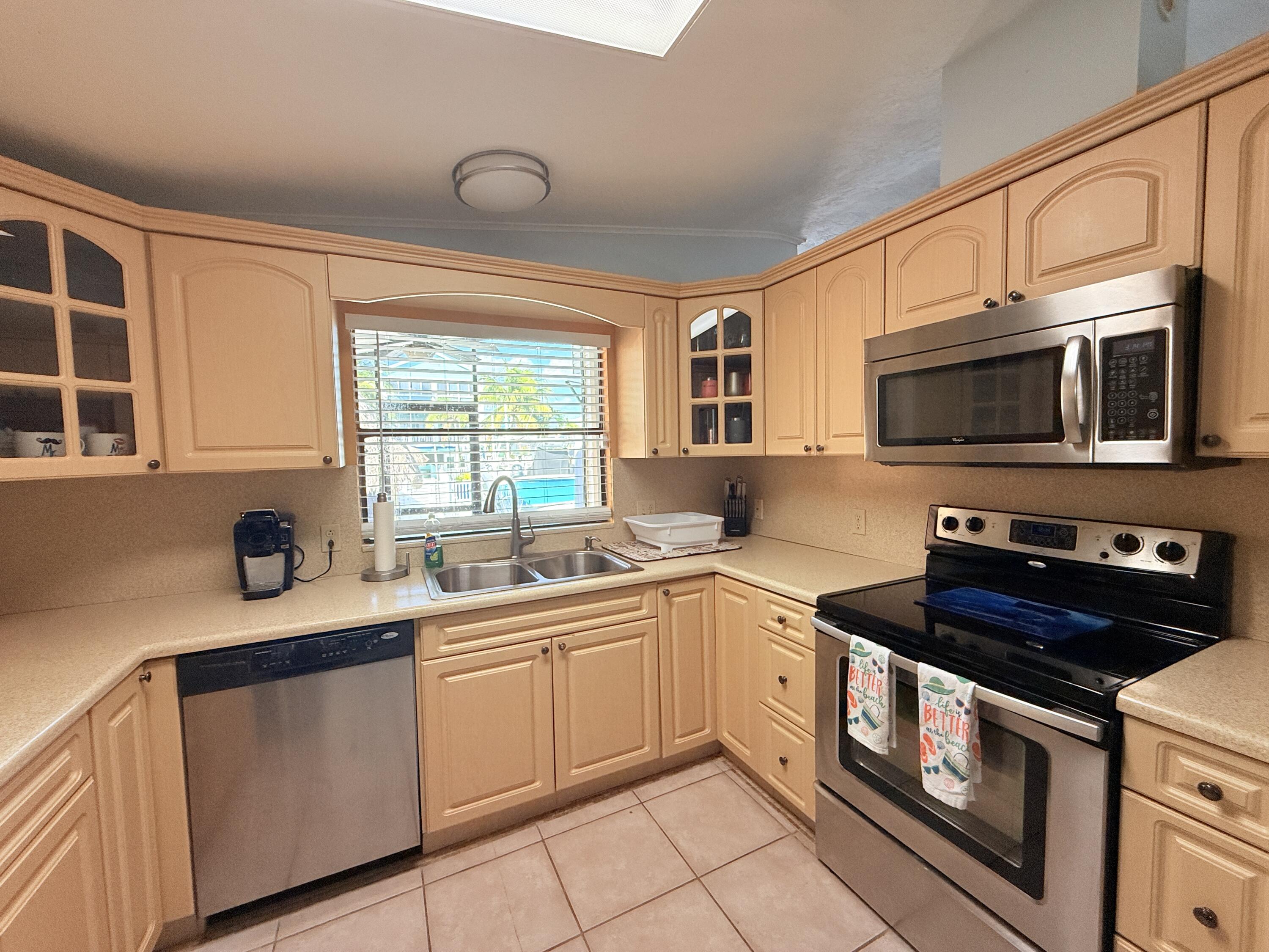 723 Boyd Drive Key Largo, FL 33037 - Photo 10 of 56 a kitchen with stainless steel appliances a stove sink microwave and cabinets