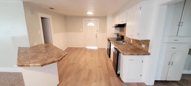 a kitchen with stainless steel appliances granite countertop a sink a stove top oven a counter space and cabinets