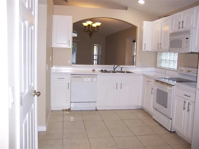 a kitchen with a stove sink and cabinets