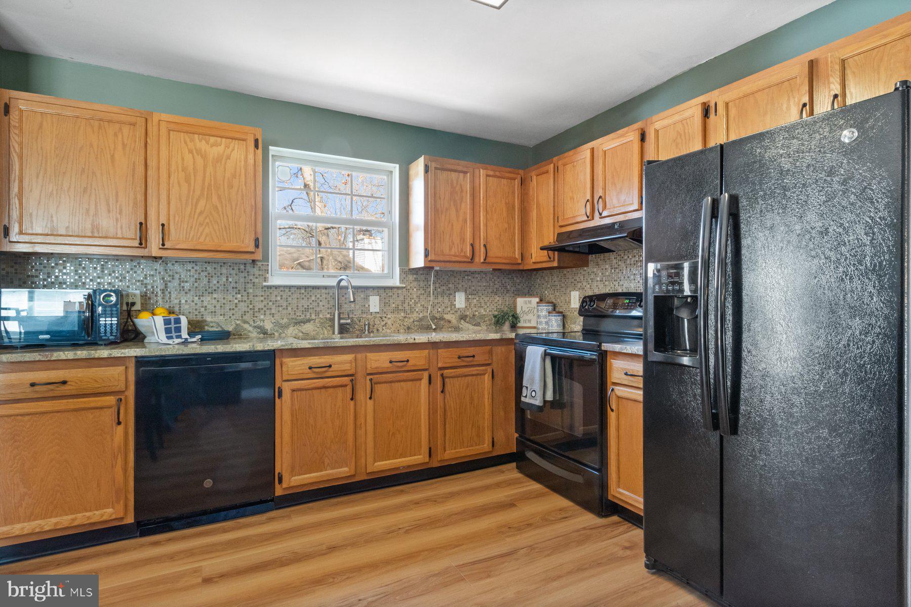 1512 Pullman Drive Severn, MD 21144 - Photo 11 of 34 a kitchen with stainless steel appliances granite countertop a refrigerator sink and cabinets