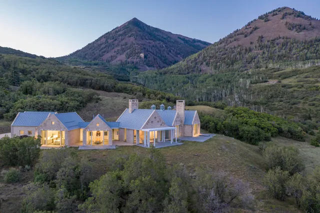 an aerial view of a house around side of green landscape