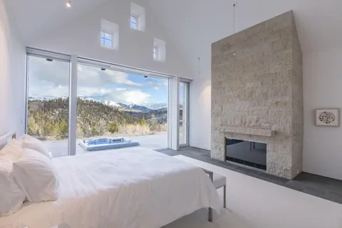 a bedroom with a large bed and a fireplace