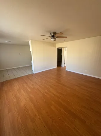a view of a big room with wooden floor and windows
