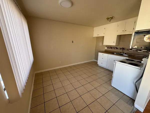 a kitchen with a sink a stove top oven and cabinetry