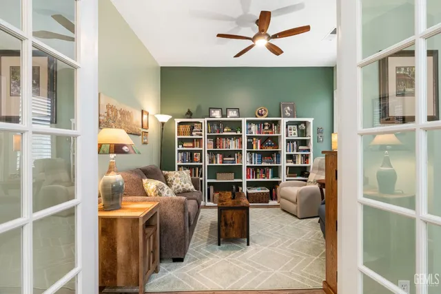 a view of a workspace with furniture and a book shelf
