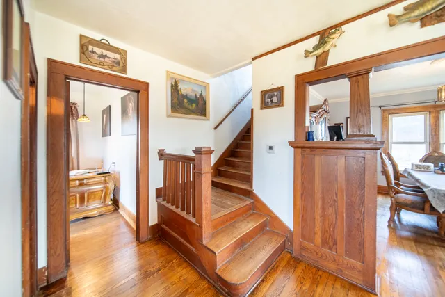a view of a hallway with wooden floor and staircase