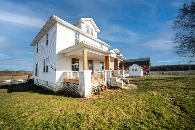 a view of a white house with garden and yard