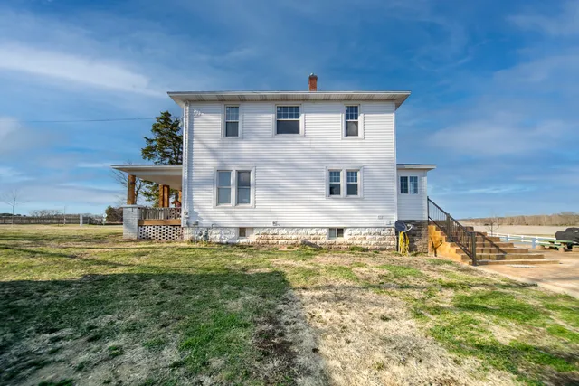 a view of a couches with wooden floor in front of house