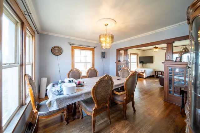 a dining room with furniture a chandelier and wooden floor