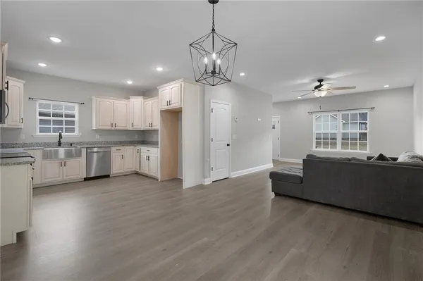 a kitchen with granite countertop a sink cabinets and stainless steel appliances
