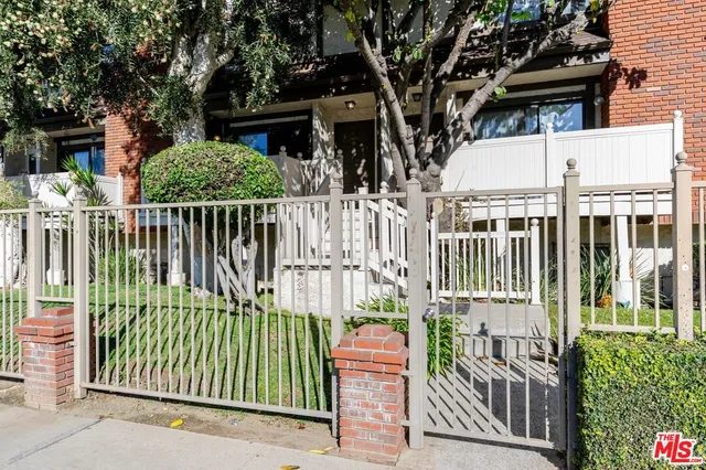 a view of a house with a small yard and wooden fence