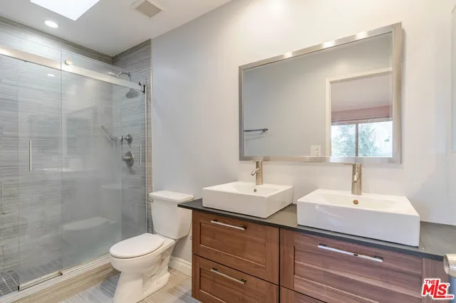 a bathroom with a sink toilet a mirror and shower