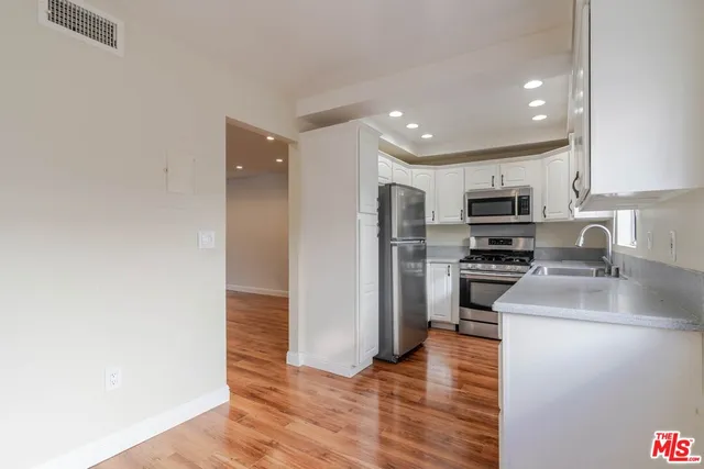 a kitchen with stainless steel appliances a refrigerator and a stove top oven
