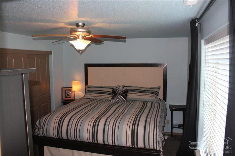 63263 Vogt Road Bend, OR 97701 - Photo 12 of 16 a bedroom with a bed and a chandelier