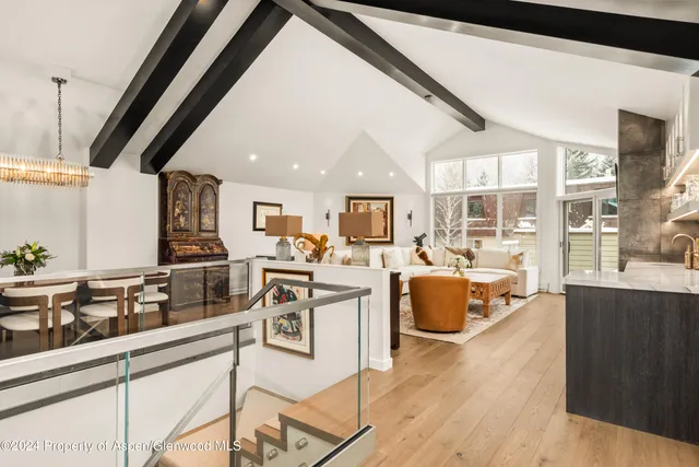 a living room with stainless steel appliances kitchen island granite countertop a couch and wooden floor