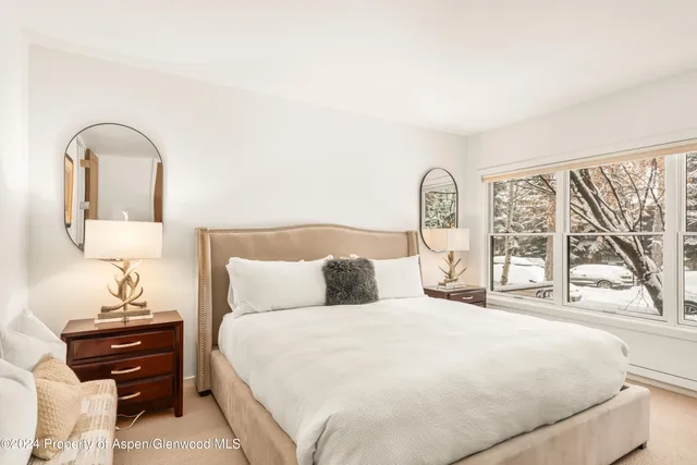 a bedroom with a bed and a large window