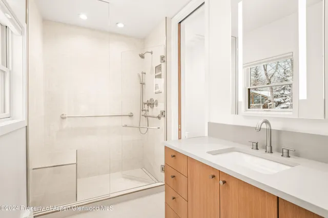 a bathroom with a double vanity sink mirror and shower