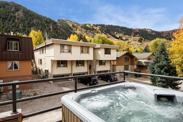 a view of a white house with a swimming pool and a chair