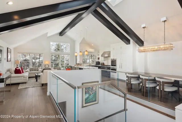 a kitchen with a sink dishwasher a stove and white cabinets with wooden floor
