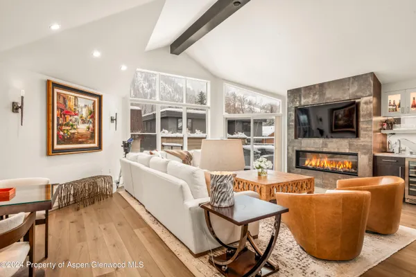 a living room with furniture a flat screen tv and kitchen view